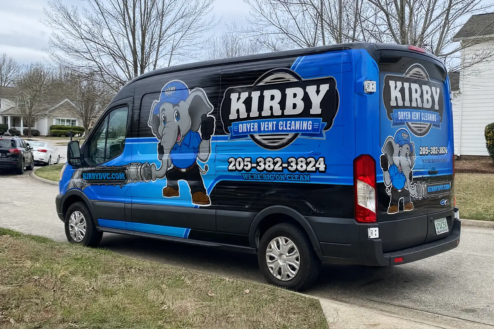 Kirby Dryer Vent Cleaning Transit van parked on a suburban street, elephant mascot and 205-382-3824 readable on the side.
